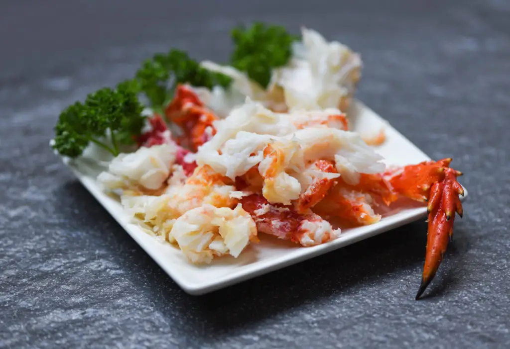 crab meat on white plate with spices for cooked seafood - red cr